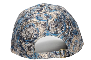 Detail of adjustable strap and antique metal buckle on blue gold jacquard baseball cap