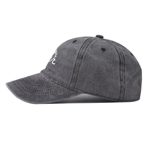 Detailopname van donkergrijze gewassen baseballcap met zon- en golfborduurwerk op zijkant