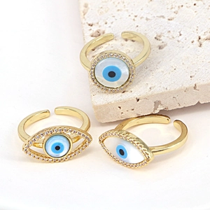 Three-piece gold-plated evil eye ring set with blue enamel and crystal inlay in white background