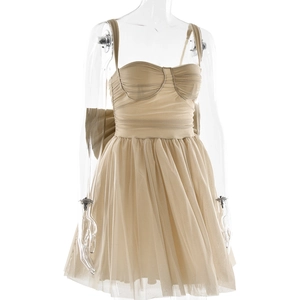 Detail of beige mesh mini dress featuring bustier bodice and large back bow decoration