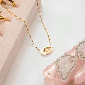 Golden Evil Eye pendant necklace with zircon crystals in a pink velvet jewelry box
