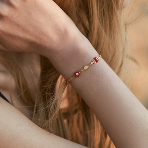 18K gold plated chain bracelet with red Hamsa hand charm and evil eye on wrist