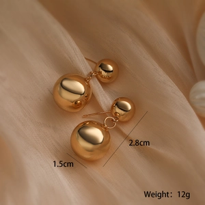 Detail showing 2.8cm length gold-plated sphere earrings with 1.5cm ball diameter