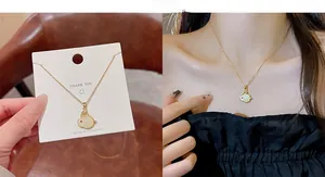 Close-up of golden titanium necklace featuring a white rabbit pendant with red details