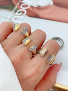 Detailed close-up of tiered gold and silver textured rings with pavé set zircon stones