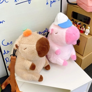 Detail of plush capybara bags in brown and pink colors with cute accessories
