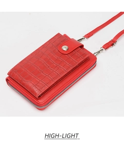 Detail view of red crocodile pattern phone bag with silver zipper and snap button closure