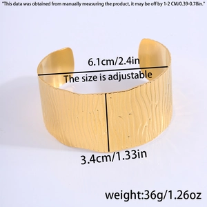 Detail view of gold open cuff bracelet with dimensions showing diameter and width