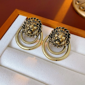 Vue détaillée de boucles d'oreilles tête de lion vintage dorées à double anneaux