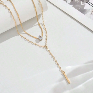 Layered Y-shaped gold necklace with teardrop crystal and minimalist bar pendant for women