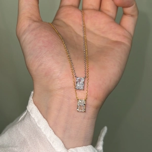 Detail of geometric perfume bottle pendant necklaces in gold and silver finish on hand