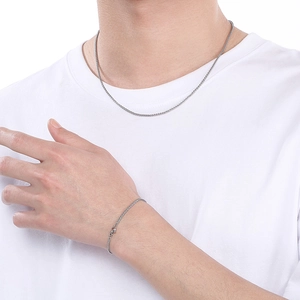 Polished stainless steel basket weave necklace and bracelet set worn by a female model