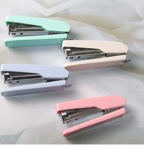 Detailed top view of portable mini staplers in pastel mint, cream, lavender, and pink colors