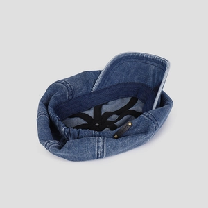 Detail view of denim cloud hat interior with adjustable strap and leather logo tag