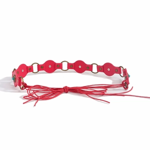 Detail of red bohemian waist belt with turquoise inlays and ethnic tassel tie