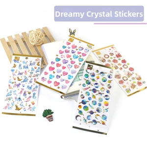 Detail of clear epoxy stickers with gold foil, cat, heart and planet designs