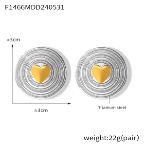 Macro view of titanium steel wavy hoop earrings with gold heart detail and 3cm size specs