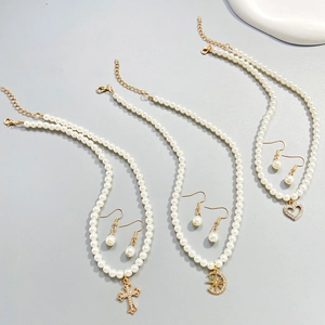 Detailed set of French vintage pearl necklaces with cross, moon, and heart pendants