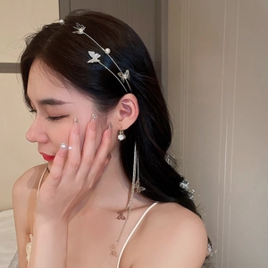 Detailed close-up of a butterfly headband with pearl accents and matching tassel earrings