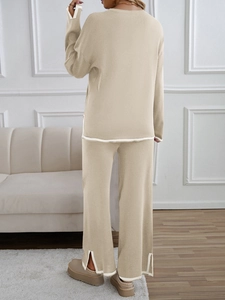 Rear view of apricot knit set with white trim details and side split pants in a living room