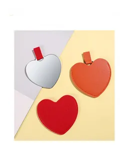 Detail of heart-shaped stainless steel travel mirrors with colorful leather sleeves