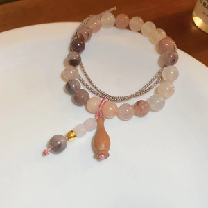 Détail du bracelet de perles style chinois avec perles d'eau douce et pendentif en bois