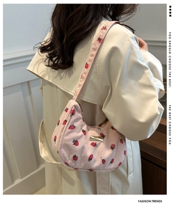 Pink corduroy underarm bag featuring red strawberry embroidery and a metal plaque detail