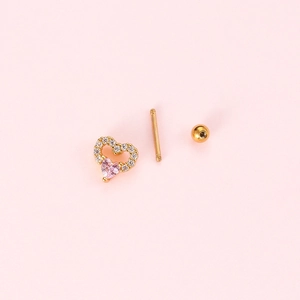 Gold heart piercing stud with pink zircon and screw back on light pink background
