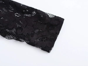 Close-up of intricate floral lace texture on the black sleeve of a women's dress