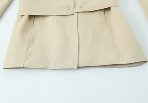 Détails du tissu en sergé kaki clair et boutons-pression argentés sur la veste tailleur