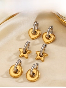 Vue détaillée des boucles d'oreilles cœur étoile et cercle sur du tissu en soie