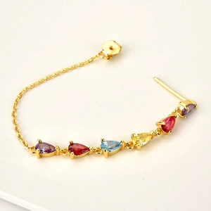Macro view of long tassel earrings with colorful teardrop zircons and gold plated chain