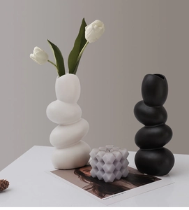 Modern pebble-shaped ceramic vases in matte black and white for artistic home decor