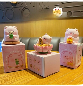 Detailed view of three cute pink resin pig figurines on boxes for desktop decoration