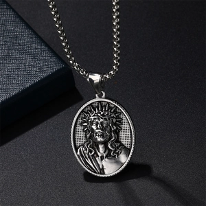 Vintage silver Jesus Christ relief pendant necklace with thorn crown on a dark background
