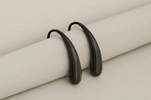 Detailed view of irregular matte black teardrop earrings with elegant streamlined hooks