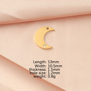 Detailed specs for gold moon pendant charm with diamond inlay on silk background