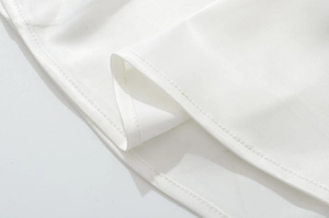 Vista macro detallada de la textura de tela blanca y costura de dobladillo en el vestido