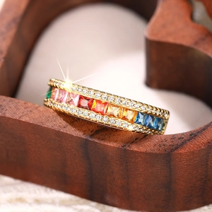 Detail of gold rainbow ring with multi-color rectangular gems and white side diamonds