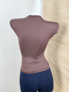 Detail shot of brown slim-fit short sleeve sports top with high-stretch athletic fabric