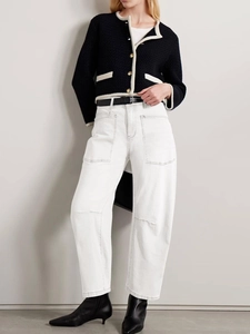 Retro deconstructed high-waisted wide-leg jeans paired with a black knit cardigan and boots