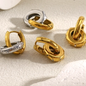 Detailed close-up of gold and two-tone hoop earrings with oval cubic zirconia charms