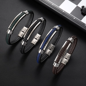 Détail de bracelets en cuir tressé vert, noir, bleu et marron avec fermoirs en acier inox
