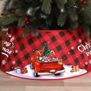 Close-up of red and black plaid Christmas tree skirt with Merry Christmas text on wood floor