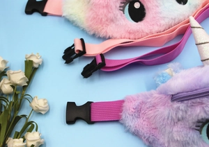 Detail of plush unicorn waist bags in pink and purple with adjustable straps and buckles