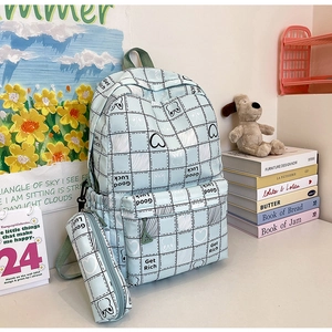 Detailed view of light blue plaid backpack with matching pencil case and cute rabbit ears