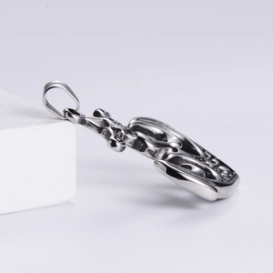 Macro side view of vintage silver rudder pendant showing the hollow-out thickness and texture