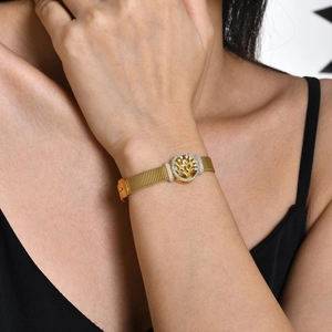 Détail macro du bracelet en maille dorée avec breloque Arbre de Vie scintillante et pierres