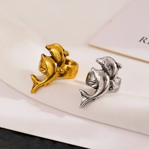 Detailed close-up of retro dolphin rings in gold and silver finish with vintage metal texture