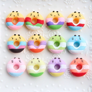 Close-up of colorful resin doughnut charms with cute faces for DIY phone case crafting